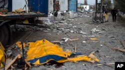 El cuerpo de un hombre está cubierto por una lona de un camión dañado luego de un bombardeo ruso de una fábrica en Kramatorsk, en el este de Ucrania, el 19 de abril de 2022.