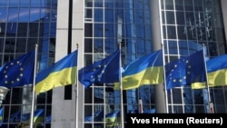 Banderas de la Unión Europea y Ucrania ondean juntas frente al Parlamento Europeo, en Bruselas, el 28 de febrero de 2022.