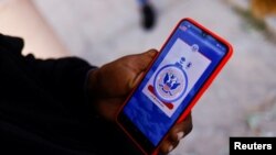 Un migrante de Venezuela que busca asilo en EEUU usa su teléfono para acceder a la aplicación CBP One de Aduanas y Protección Fronteriza (CBP) de EEUU para solicitar una cita al país, afuera de un albergue en Ciudad Juárez, México, el 12 de enero de 2023.