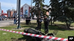 Militares ucranianos junto a un fragmento de un misil Tochka-U después del bombardeo ruso en la estación de tren de Kramatorsk, Ucrania, el viernes 8 de abril de 2022. (Foto AP/Andriy Andriyenko)