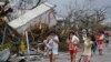 Residents cover their nose from the smell of dead bodies in Tacloban city, Leyte province central Philippines on Sunday, Nov. 10, 2013. 