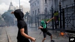 Manifestantes lanzan piedras frente al Congreso en Buenos Aires, Argentina, mientras los legisladores se preparan para ratificar el acuerdo del gobierno con el Fondo Monetario Internacional para refinanciar unos 45.000 millones de dólares en deuda el 10 de marzo de 2022.