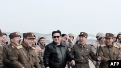 Esta imagen publicada por la Agencia Central de Noticias de Corea del Norte el 24 de marzo de 2022 muestra al líder norcoreano Kim Jong Un (centro) caminando con personal militar durante la prueba de lo que los medios estatales informan es un nuevo misil balístico intercontinental a una velocidad no revelada.