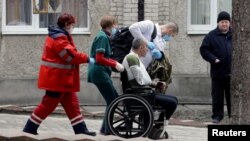 Un militar herido es escoltado por trabajadores médicos, luego de un ataque a la base militar de Yavoriv, en medio de la invasión rusa de Ucrania, en un hospital en Novoyavorivsk, Ucrania, el 13 de marzo de 2022.