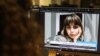 FILE - A woman looks at a screen image of Nazila Maroufian, detained in Iran for coverage of protests, Nov. 4, 2022. 