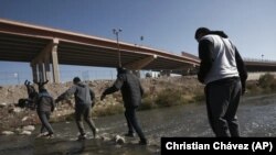 Migrantes cruzan el río Grande hacia la frontera entre México y Estados Unidos, el lunes 19 de diciembre de 2022, en Ciudad Juárez, México. 