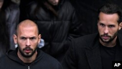 Andrew Tate, left, and Tristan Tate leave after appearing at the Court of Appeal, in Bucharest, Romania, Jan.10, 2023.