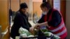 Zohra, a la izquierda, recibe alimentos gratis en el Ejército de Salvación en París.