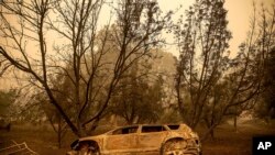 Un vehículo calcinado junto a un camino de entrada mientras el incendio McKinney arde en el Bosque Nacional Klamath, California, el domingo 31 de julio de 2022. (Foto AP/Noah Berger)