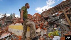 Un militar ucraniano mira los escombros de una escuela que fue destruida hace algunos días durante un ataque con misiles en las afueras de Kharkiv, Ucrania, el 5 de julio de 2022.