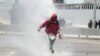 Un manifestante en Tegucigalpa, Honduras, es golpeado por un cañón de agua de la policía durante una protesta contra los planes del gobierno para privatizar la salud y la educación. Mayo 30 de 2019. REUTERS/Jorge Cabrera.