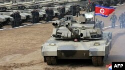 Esta fotografía tomada el 13 de marzo de 2024 y publicada al día siguiente por la agencia oficial de noticias de Corea del Norte, KCNA, muestra al líder norcoreano Kim Jong Un conduciendo un tanque.