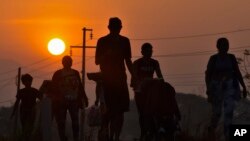 Migrantes caminan al amanecer por la carretera que atraviesa Arriaga, estado de Chiapas, un paso peligroso en el sur de México, el lunes 8 de enero de 2024, durante su viaje hacia el norte hacia la frontera con Estados Unidos.