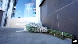 Un ramo de flores fue colocado frente a la puerta de un estudio de tatuajes South Broadway el martes 28 de diciembre de 2021, en Denver. Esta fue una de las escenas de un tiroteo que dejó cinco personas muertas, incluido el presunto tirador el lunes por la noche.
