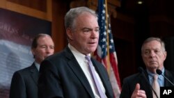El senador Tim Kaine, demócrata por Virginia (centro) habla con los reporteros en una sesión en el Capitolio.