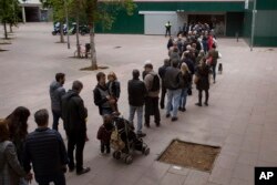 Españoles hacen fila para votar en las elecciones generales del domingo 28 de abril de 2019, en Barcelona.