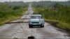 ARCHIVO - Un auto recorre una carretera llena de cables eléctricos caídos tras el paso del huracán Rafael en San Antonio de los Baños, Cuba, el 7 de noviembre de 2024. 