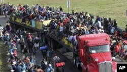 Los migrantes centroamericanos se suben a un remolque de dieciocho ruedas, en Irapuato, México, el lunes 12 de noviembre de 2018.
