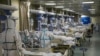 Empleados médicos usando trajes protectores atienden a pacientes de coronavirus en una unidad de cuidados intensivos en un hospital en Wuhan el 6 de febrero de 2020.
