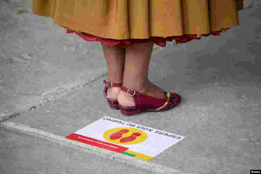 Votantes tienen que respetar los marcadores de distanciamiento social ubicados en los colegios electorales durante las elecciones presidenciales en La Paz, Bolivia, el 18 de octubre de 2020.