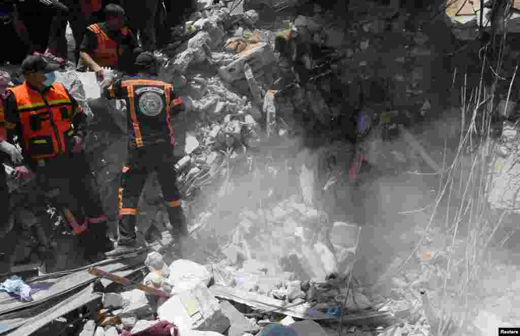 Los rescatistas palestinos recuperan el cuerpo de una v&#237;ctima entre los escombros en el lugar de los ataques a&#233;reos israel&#237;es, en la ciudad de Gaza.