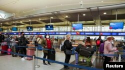 Los pasajeros hacen fila en el Aeropuerto Internacional John F. Kennedy, de Nueva York, después de que las aerolíneas anunciaron que se cancelaron numerosos vuelos, el 24 de diciembre de 2021.
