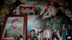 Retratos del fallecido presidente de Venezuela, Hugo Chávez, rodeados de imágenes religiosas dentro de una pequeña capilla, en el barrio 23 de Enero de Caracas, Venezuela.