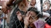 Typhoon survivors queue up at Tacloban city airport hoping to be able to board U.S. and Philippine military transport planes, Nov. 13, 2013, in Tacloban city, Leyte province in central Philippines. 