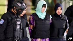 越南被告段氏香(中)庭审结束后在警察押送下离开(2018年6月28日美联社)