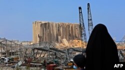 Una mujer y su pequeño hijo contemplan los dañados silos en el puerto de Beirut, ocho días después de una enorme explosión que desfiguró la capital libanesa. Agosto 12 de 2020.