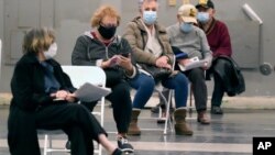 Las personas que recibieron una vacuna contra elCOVID-19 se distancian socialmente mientras esperan los quince minutos requeridos para monitorear las posibles reacciones adversas después de recibir la vacuna en Fair Park en Dallas, el 20 de enero de 2021.