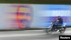 Vista general de un mural para la campaña a la reelección del presidente Nicolás Maduro, en Caracas. Especialistas resaltan cómo el chavismo ha matizado su tradicional rojo en cada una de sus campañas desde 2006.