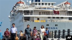 乘客离开停靠在韩国济州岛的中国游轮海娜号