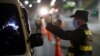 Un policía chequea los documentos de un conductor y autorización de viajar en un punto de control de la cuarentena en San Salvador, El Salvador, el 7 de abril de 2020.