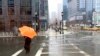 ARCHIVO - Una persona se prepara para protegerse del viento mientras cae una mezcla invernal de nieve y lluvia en Boston, el 14 de marzo de 2023. Se espera que un sistema climático invernal que se mueve a través de EEUU azote la costa este este fin de semana.