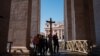 Pilgrims carry a wooden cross at St Peter's square in the Vatican as Pope Francis is still hospitalized with pneumonia on March 06, 2025.
