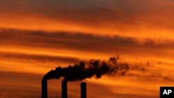 FILE - Smokestacks at the Jeffrey Energy Center coal power plant as the suns sets near Emmett, Kan. 