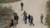 ARCHIVO: Agentes fronterizos y miembros de la Guardia Nacional de Texas detienen a inmigrantes que cruzaron la frontera desde México a EEUU en La Joya, Texas, el 17 de marzo de 2023.