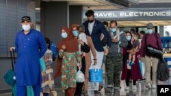 Familias evacuadas desde Afganistán llegan al aAeropuerto Internacional Washington-Dulles en Estados Unidos, el martes 31 de agosto de 2021.