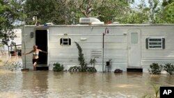 Una mujer sale de su casa móvil en medio de una inundación en el condado de Harris, cerca de Houston, Texas, el 4 de mayo de 2024. 