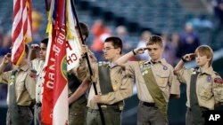 A color guard of Boy Scouts from the Chief Seattle Council salute during the national anthem before a baseball game between the Seattle Mariners and Houston Astros in Seattle, May 25, 2014.
