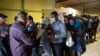 ARCHIVO - Varias personas hacen fila para abordar un autobús que los llevará al aeropuerto de San Antonio en un almacén manejado por el grupo sin fines de lucro Mission: Border Hope, operado por la Iglesia Metodista Unida, en mayo de 2022, en Eagle Pass, EEUU. 