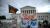 Personas sostienen carteles contra Trump frente a la Corte Suprema de Estados Unidos el 1 de julio de 2024, en Washington, DC. 