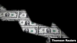 FILE PHOTO: Dollar banknotes are seen through printed stock graph in this illustration