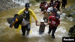 Un grupo de migrantes de Venezuela, Ecuador y Haití, cruzan el Río Muerto en la Selva del Darién, entre Colombia y Panamá, el 9 de Julio de 2023.