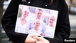 Un simpatizante sostiene una foto de Navalny y su familia en las afueras de la embajada rusa en Berlín.