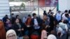 Des Palestiniens ayant la double nationalité se rassemblent devant le poste frontière de Rafah avec l'Égypte.