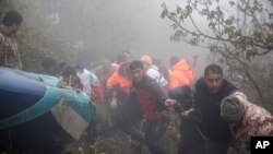 En esta fotografía proporcionada por la agencia de noticias Moj, miembros del equipo de rescate trabajan en el lugar del accidente del helicóptero que transportaba al presidente iraní Ebrahim Raisi en Varzaghan, en el noroeste de Irán, el lunes 20 de mayo de 2024.