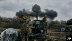 Soldados ucranianos disparan una pieza de artillería contra posiciones rusas cerca de Bájmut, en el este de Ucrania, el 7 de marzo de 2023.