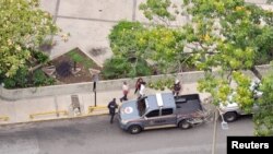 La periodista venezolana Carmela Longo camina hacia un vehículo policial mientras es detenida por la policía que allanó su casa, en Caracas, Venezuela, el 25 de agosto de 2024, según denunció el sindicato de la prensa venezolana. 